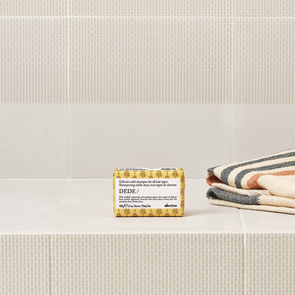 Davines Dede Solid Shampoo bar shown in a styled bathroom setting
